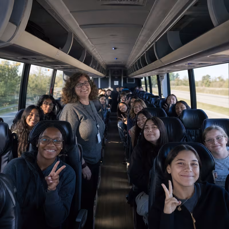 Group boarding a white charter bus for School Transportation transportation in Las Vegas